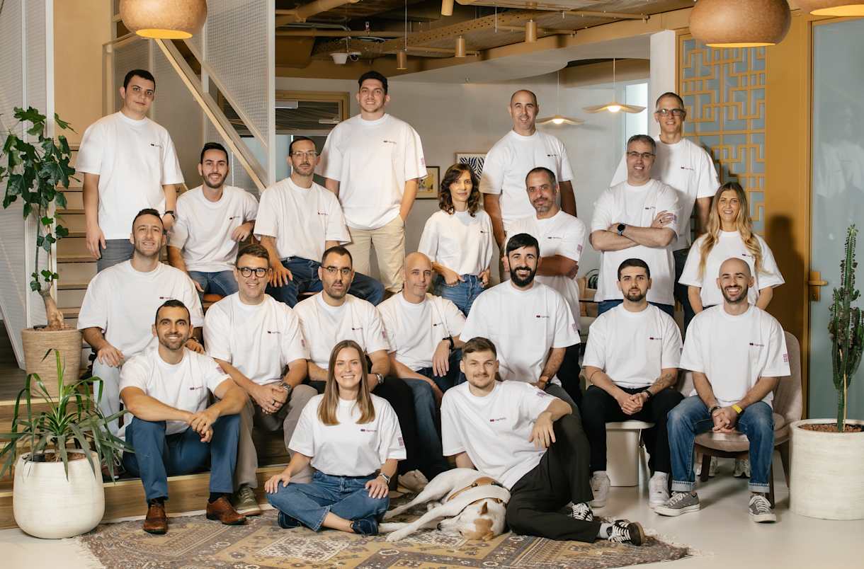 The Harmony team in matching white t-shirts posing for a group photo in their office