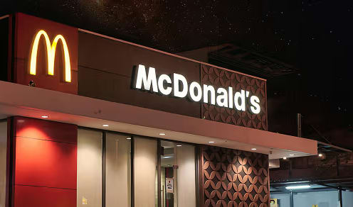 Customer testimonial background — McDonald's storefront at night