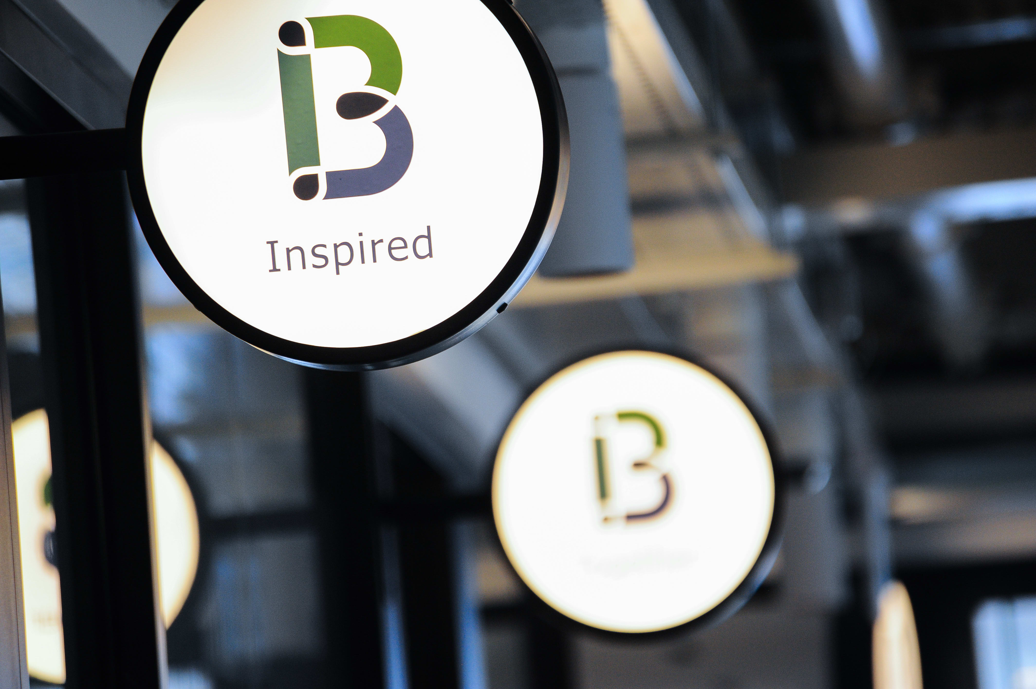 Behalf logo on a lit sign that reads "B inspired"